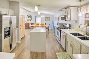A modern kitchen with a central island, stainless steel appliances, and wooden cabinets. - Waterfront Michigan Center Home w/ Boat Dock! (Michigan Center)