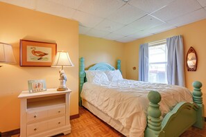 A bedroom with a bed, a nightstand, a lamp, a framed picture of a bird, and a window with curtains. - Waterfront Michigan Center Home w/ Boat Dock! (Michigan Center)