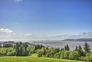 A scenic view of a coastal area with a prominent bridge, lush greenery, and a body of water. - Waterfront Condo on Pier in Downtown Astoria! (Astoria)