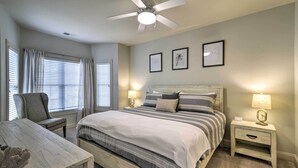 A bedroom with a bed, nightstands, a chair, a desk, and a ceiling fan. - 3 Mi to Myrtle Beach: Coastal Condo w/ Pool! (Myrtle Beach)