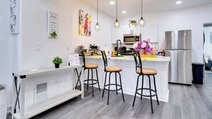 A modern kitchen with a central island, bar stools, pendant lighting, and stainless steel appliances. - Philly Hub Near Intl Soccer, Downtown Attractions (Philadelphia)