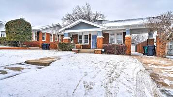 Welcome to this charming home with a front porch and blue door, featuring a convenient entrance and ample outdoor space.