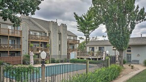 Un immeuble résidentiel doté de nombreux balcons, d’une piscine et d’un jardin bien entretenu.