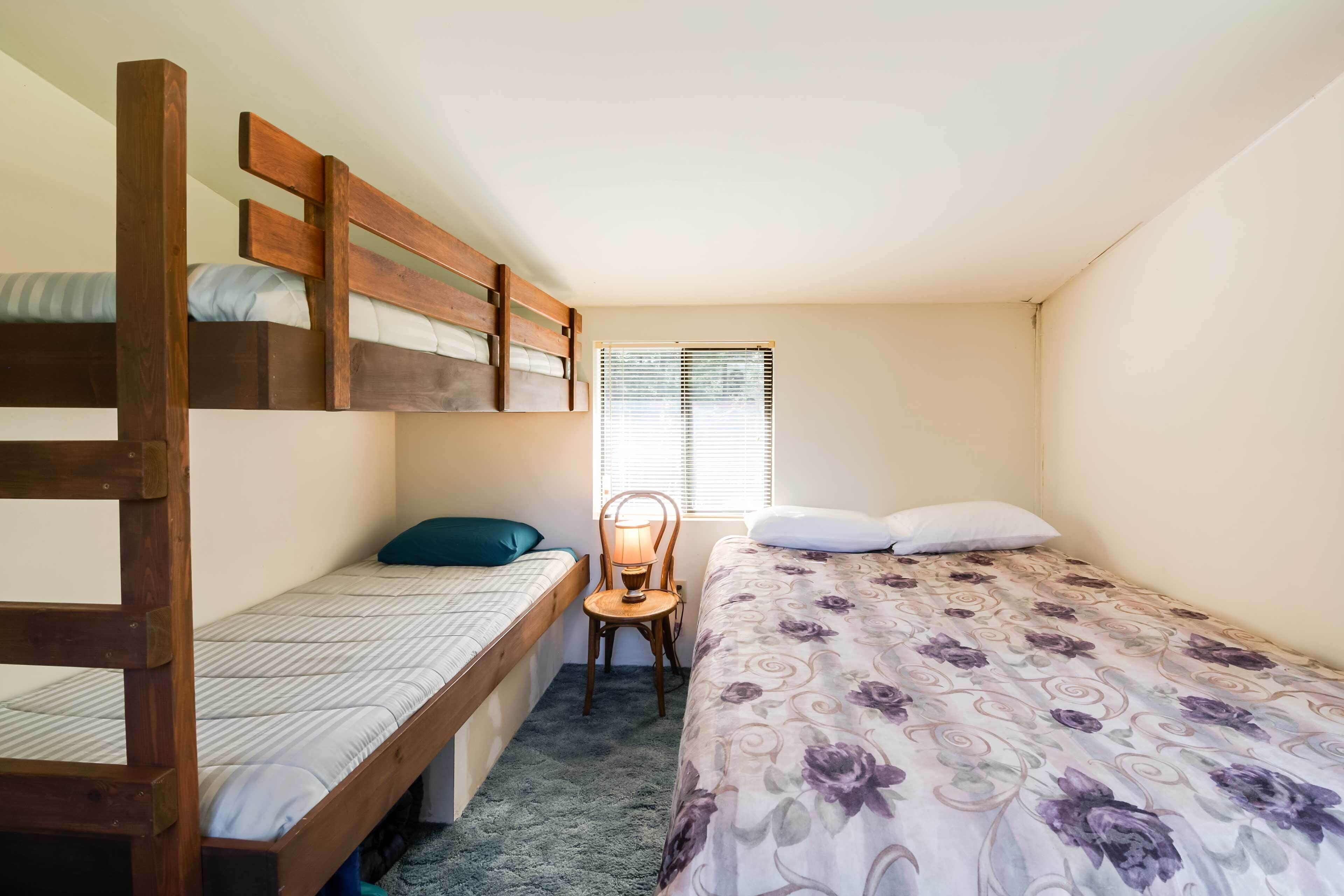 Acomodação pequena e individual com beliche, cama de solteiro, escrivaninha e cadeira.