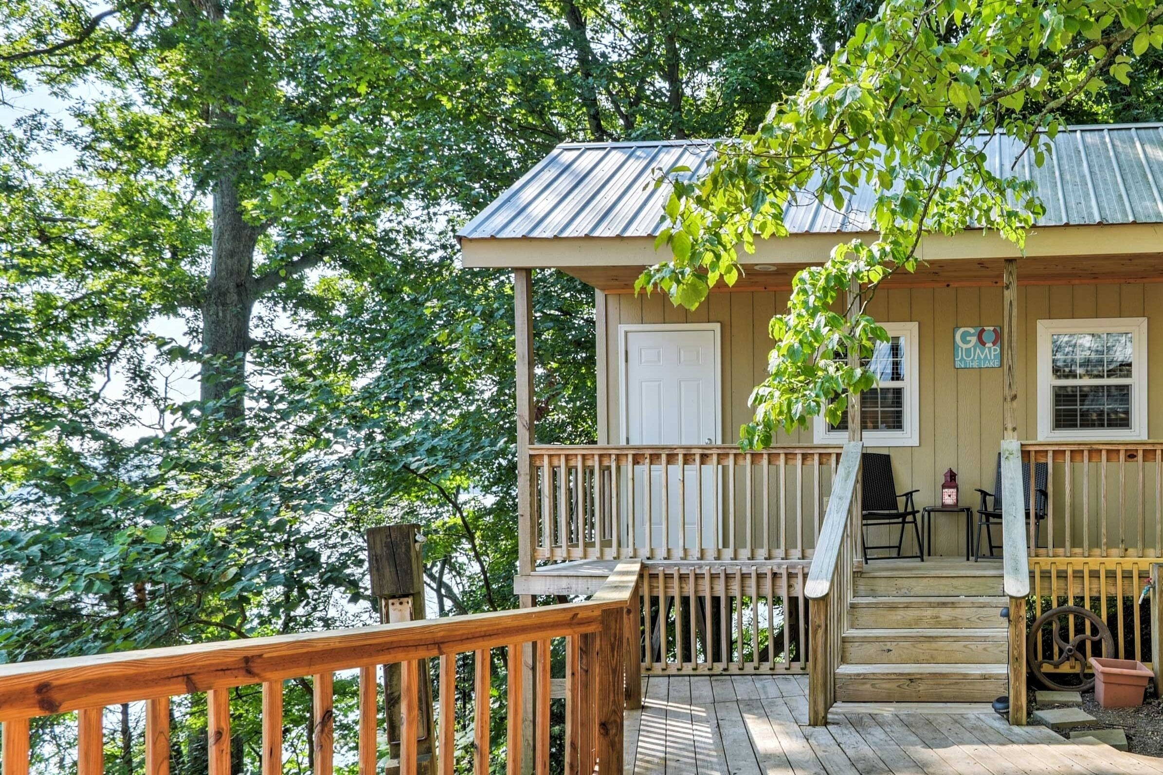 A wooden cabin with a porch, a door, and a small table with chairs.