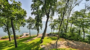 Un terrain de camping au bord du lac, équipé d’un quai, de tables de pique-nique et d’une zone herbeuse.