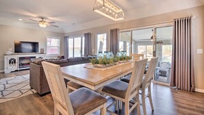 A spacious living room with a large sectional sofa, a wooden dining table with four chairs, a ceiling fan, and a modern pendant light. - Private Boat Dock: Bright Lake Ozark Home! (Lake Ozark)