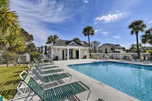 A swimming pool with lounge chairs and a building with a sign that reads "SOLITELY NO GLASS AREA". - Sunset Beach Resort Condo in Golf Community! (Sunset Beach)