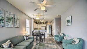 A modern living room with a sofa, armchairs, and a dining area. - Sunset Beach Resort Condo in Golf Community! (Sunset Beach)