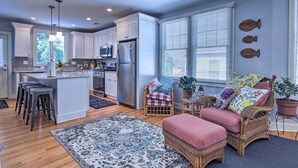 A modern kitchen with white cabinets, stainless steel appliances, and a central island with bar stools. - New London Hideaway Near Beaches & Local Spots! (New London)