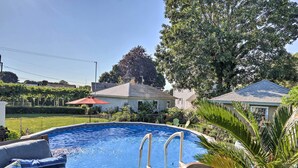 An outdoor swimming pool with a wooden deck, lounge chairs, and a palm tree. - New London Hideaway Near Beaches & Local Spots! (New London)