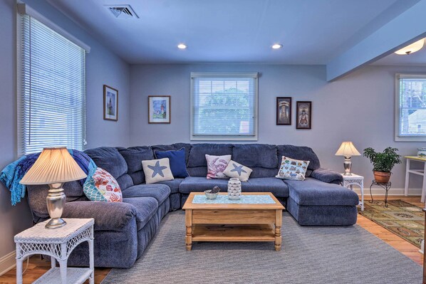 A living room with a blue sofa, a wooden coffee table, and a small white side table with a lamp.