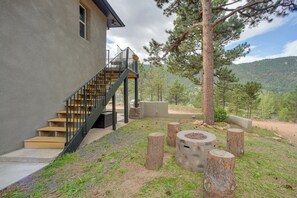 A modern building with a staircase leading to a balcony, surrounded by trees and a mountainous landscape. - Homey Mtn View Escape: 11 Mi to Garden of the Gods (Cascade)