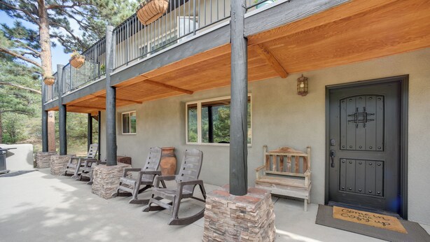 A two-story building with a balcony, stone pillars, and a wooden deck. - Homey Mtn View Escape: 11 Mi to Garden of the Gods (Cascade)