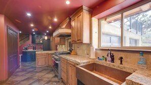 A kitchen with wooden cabinets, a large sink, and a window overlooking a balcony. - Homey Mtn View Escape: 11 Mi to Garden of the Gods (Cascade)