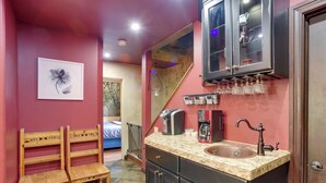 A compact kitchen with a granite countertop, a sink, and a coffee maker. There is a wooden bench and a framed picture on the wall. - Homey Mtn View Escape: 11 Mi to Garden of the Gods (Cascade)