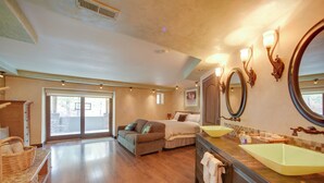 A spacious bedroom with a large bed, a sofa, and a view through a sliding door to an outdoor area. - Homey Mtn View Escape: 11 Mi to Garden of the Gods (Cascade)