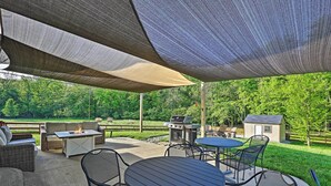 An outdoor patio area with a grill, seating, and a small shed. - Spacious Family Home w/ Fire Pits, Large Yard (Goshen)