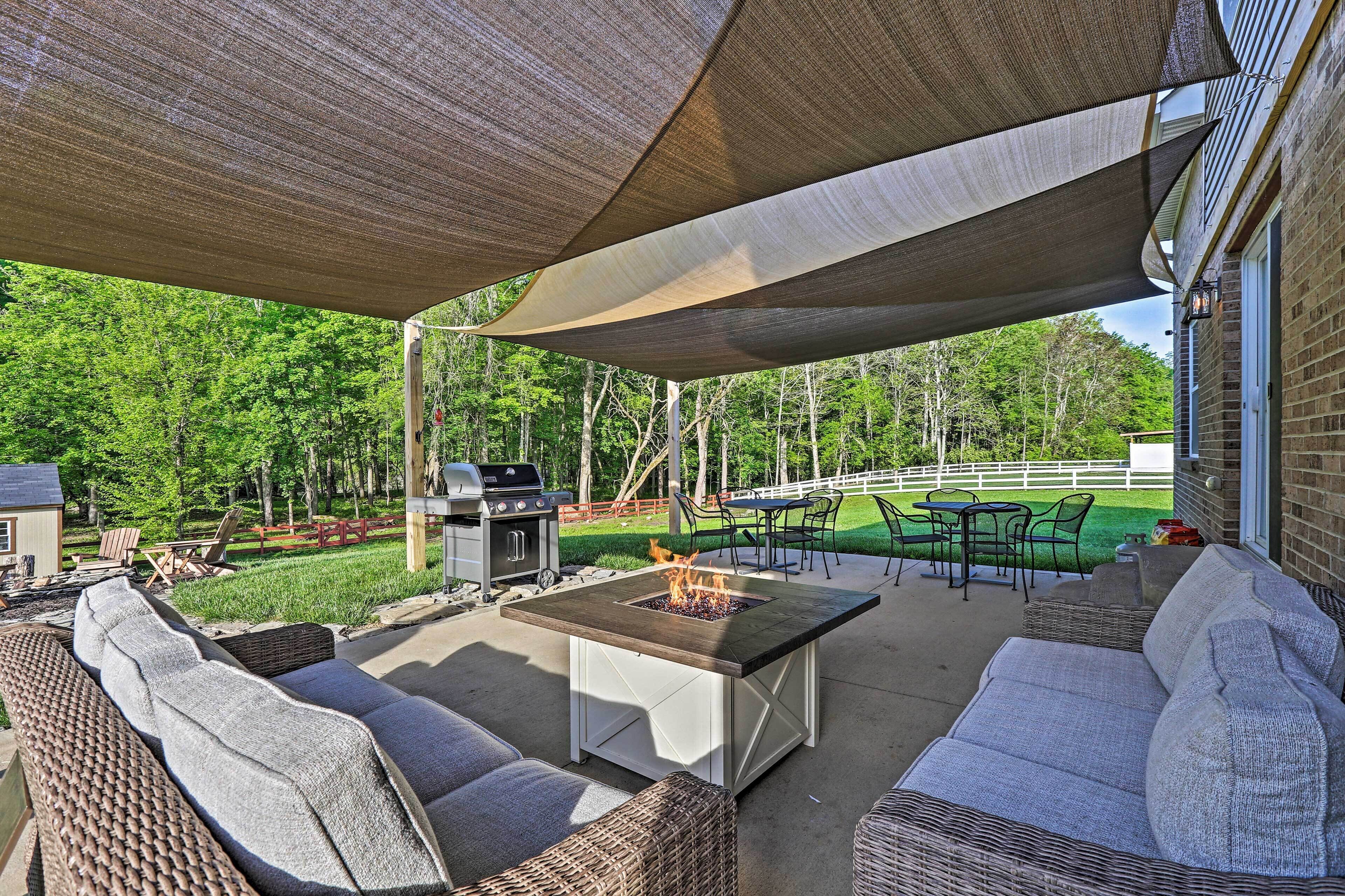 An outdoor patio with a fire pit, wicker furniture, and a barbecue grill.