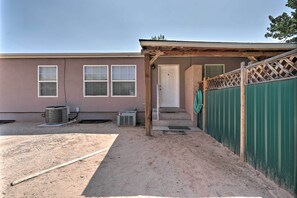 A residential building with a covered porch, a green fence, and a door. - 'rustic Retreat' Moab Townhome w/ Grill & Fire Pit (Moab)