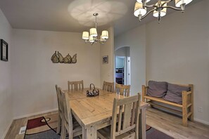 A dining area with a wooden table and chairs, a bench, and a chandelier. - 'rustic Retreat' Moab Townhome w/ Grill & Fire Pit (Moab)
