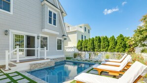 A swimming pool with lounge chairs, a wooden deck, and a white fence. - Spacious Avalon Beach House - 2 Blocks to Water! (Avalon)