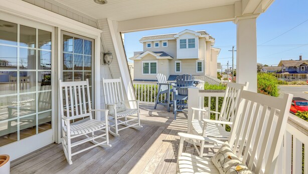 A covered porch with white wooden furniture, including chairs and a table. - Spacious Avalon Beach House - 2 Blocks to Water! (Avalon)