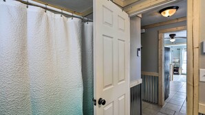 A hallway with a white door, a white textured shower curtain, and a ceiling fan. - Lakefront Retreat w/ Fire Pit & Dock in Castlewood (Castlewood)