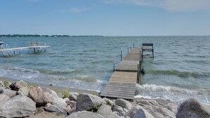 A wooden pier extending into calm waters with a bench at the end. - Lakefront Retreat w/ Fire Pit & Dock in Castlewood (Castlewood)
