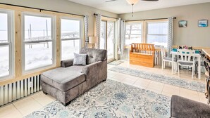 A cozy living room with a grey sofa, a wooden coffee table, and a dining area with white chairs and a wooden table. - Lakefront Retreat w/ Fire Pit & Dock in Castlewood (Castlewood)