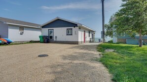 A single-story house with a gravel driveway, a small front yard, and a visible trash bin. - Lakefront Retreat w/ Fire Pit & Dock in Castlewood (Castlewood)