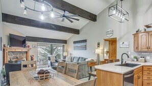 A modern kitchen with a wooden island, built-in cabinets, and a large window. - Colorado Escape w/ Pool Access & Mountain Views! (Avon)