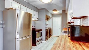 Una cocina moderna con electrodomésticos de acero inoxidable, encimeras de madera y un horno empotrado.