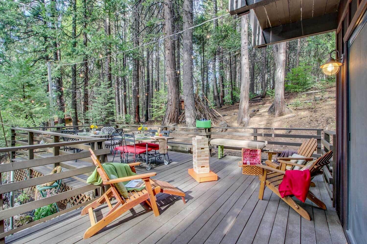 A wooden deck with outdoor furniture, a table, and a chair.