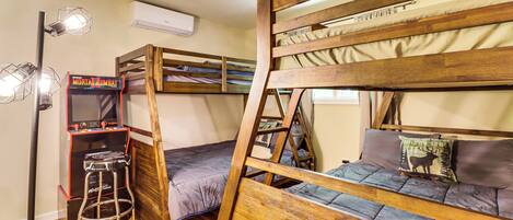 Een stapelbed met een ladder, een klein krukje en een videospelconsole.