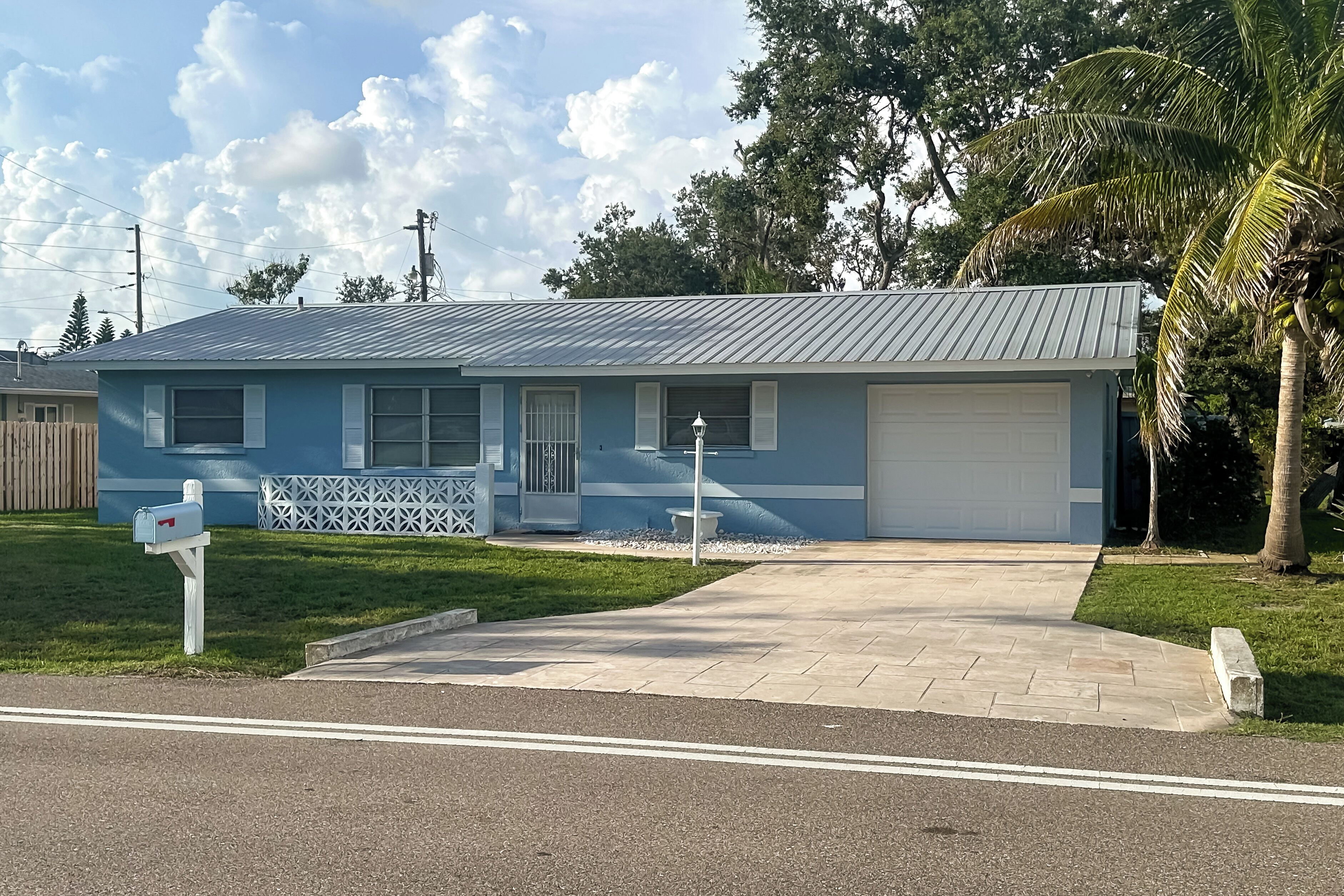 A single-story house with a garage, a front porch, and a small lawn.