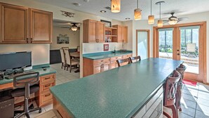 A kitchen with wooden cabinets, a large island, and pendant lighting. - The Aviator's Dream: Pool, Spa & Private Runway! (Port Orange)