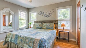 A bedroom with a large bed, a ceiling fan, and a wall with a 'Give thanks' sign. - 1 Mi to Dtwn: Family-friendly Brenham Bungalow! (Brenham)