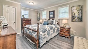 Un dormitorio con cama de madera, cómoda, mesita de noche y una silla.