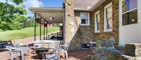 A patio with outdoor furniture, a brick wall, and a stone staircase.