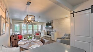 A spacious kitchen with a dining area, large windows, and a fireplace.