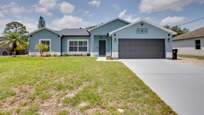 A two-story house with a light blue exterior, a front garage, and a well-maintained lawn. - Renovated Sunny Port St Lucie Home w/ Outdoor Pool (Port Saint Lucie)