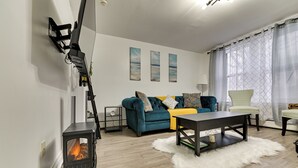 A living room with a fireplace, a sofa, a coffee table, and a chair. - Walk to Downtown Albany: Ten Broeck Triangle Apt! (Albany)
