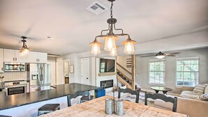 A spacious kitchen with a central island, stainless steel appliances, and a dining area with a wooden table. - Private Fishing Dock: Grand Lake Home (Eucha)