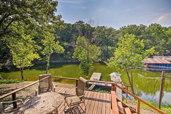 Relax on the deck overlooking a serene lake surrounded by lush greenery, perfect for a peaceful retreat.