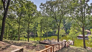 A wooden deck with a view of a lake surrounded by trees. - Private Fishing Dock: Grand Lake Home (Eucha)