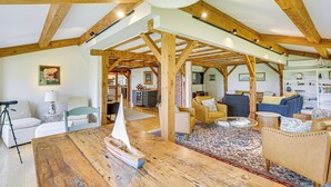 A spacious loft with high ceilings and exposed wooden beams, furnished with a variety of seating options and a large wooden table. - Spacious Kennebunkport Home w/ View, 2 Mi to Beach (Kennebunkport)