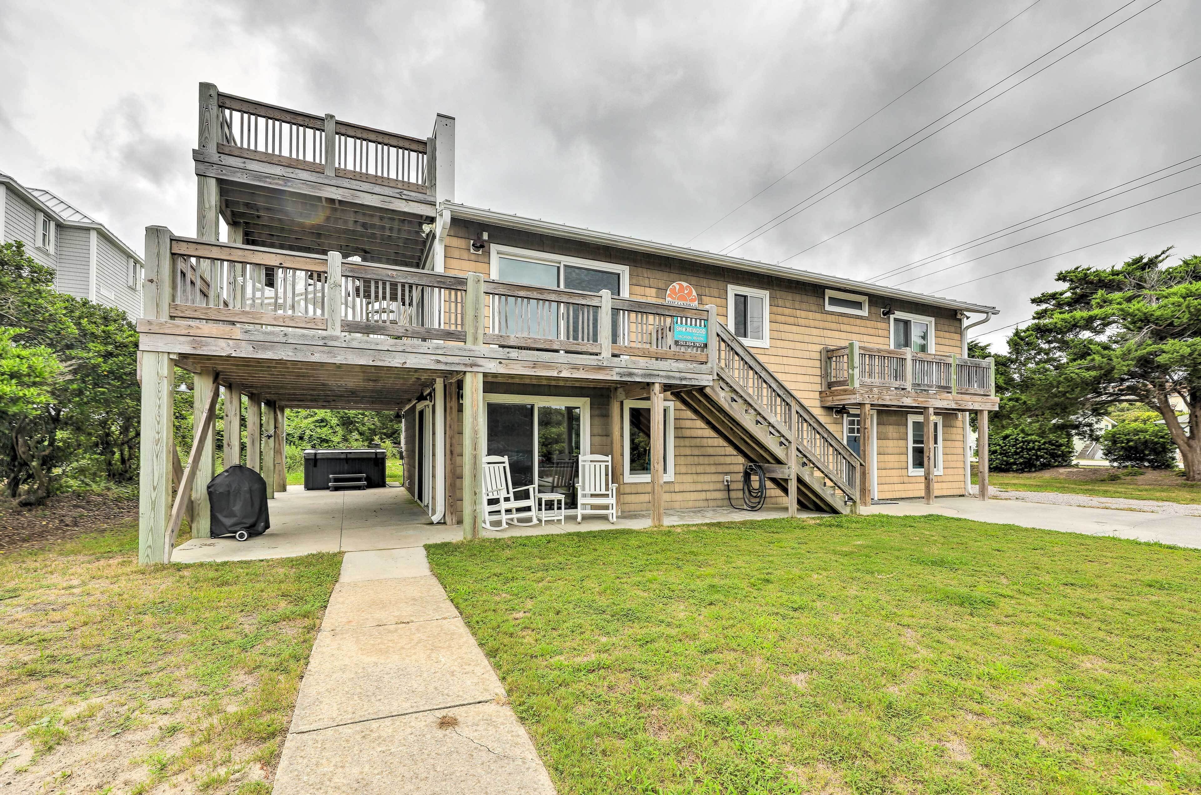 A two-story house with a balcony, a covered patio, and a staircase leading to the upper level.