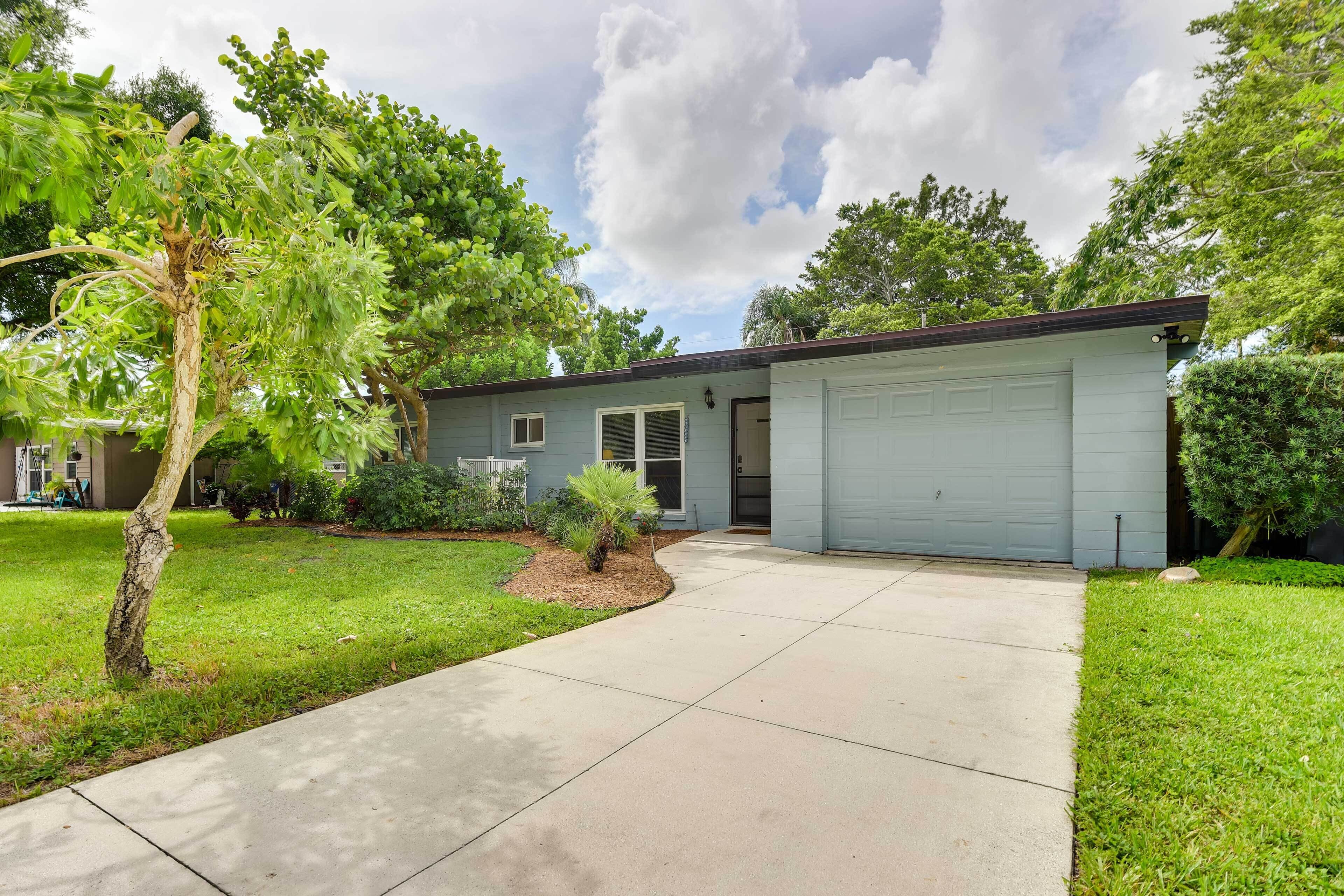 A single-story house with a garage, a driveway, and a well-maintained lawn.