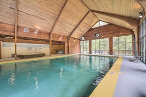An indoor swimming pool with wooden beams, a diving board, and a bench area. - Alpine Getaway w/ Grill: Walk to Lake! (Cashiers)